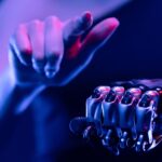 Tightly cropped, stylized image of a person with a robotic arm pointing at the viewer (shoulder to torso view).