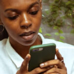 Young woman on her cellphone looking at the screen