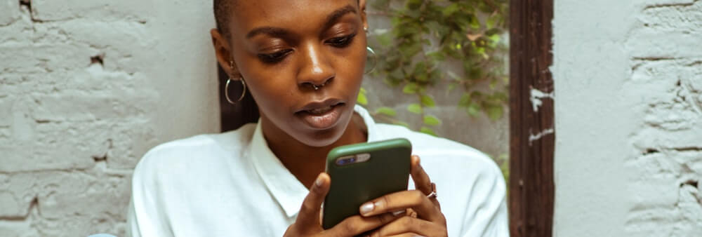 Young woman on her cellphone looking at the screen